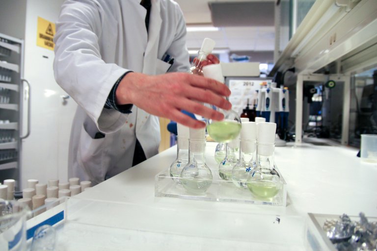 Scientist holding bottle with green content