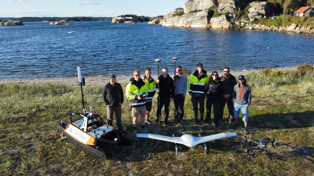 Personer med droner på strand