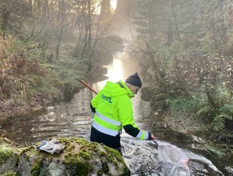 Researcher gathering water samples in a river