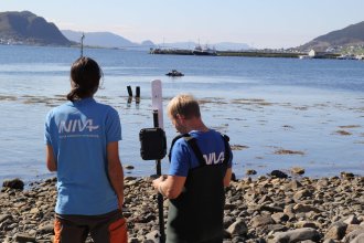 Researchers scouting out over water, operating equipment