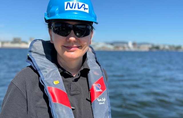 Kvinne med solbriller på sjøen