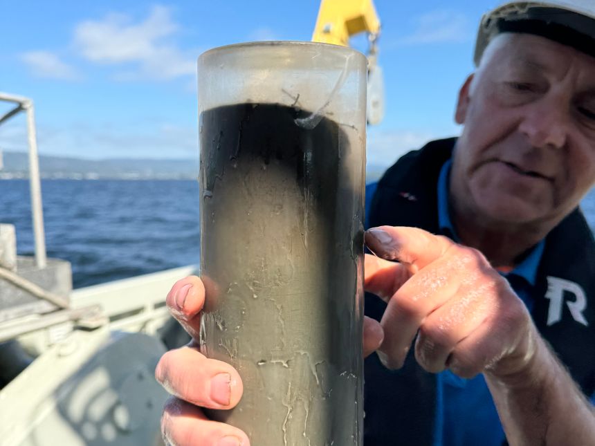 Mann som peker på rør med sediment