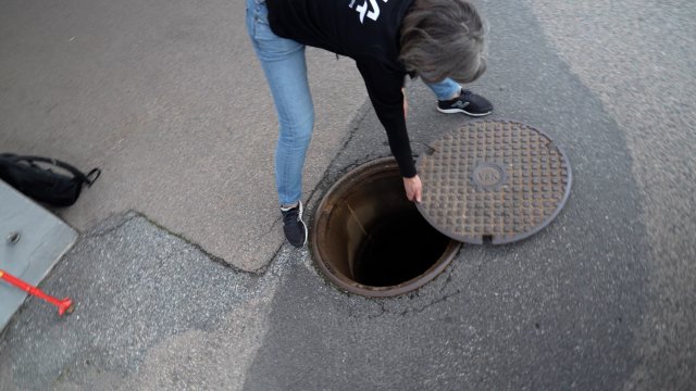 Prosjektleder Vanja Alling åpner et kumlokk