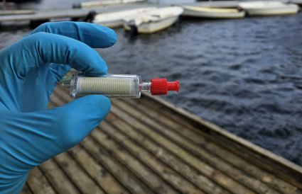 Hånd holder liten plastbeholder